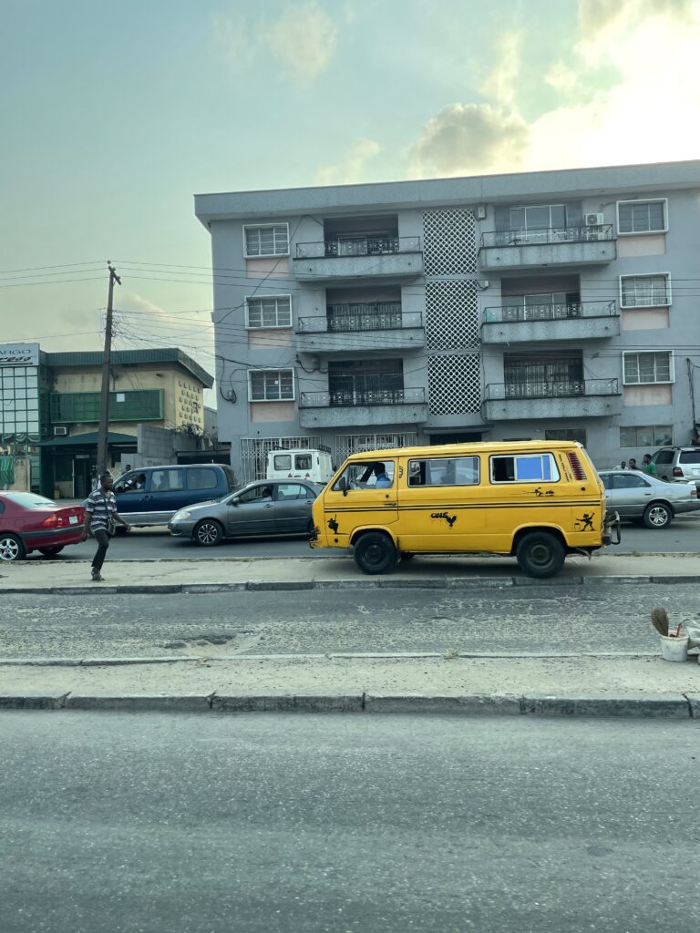 Yellow bus or danfu, on a Lagos residential street.